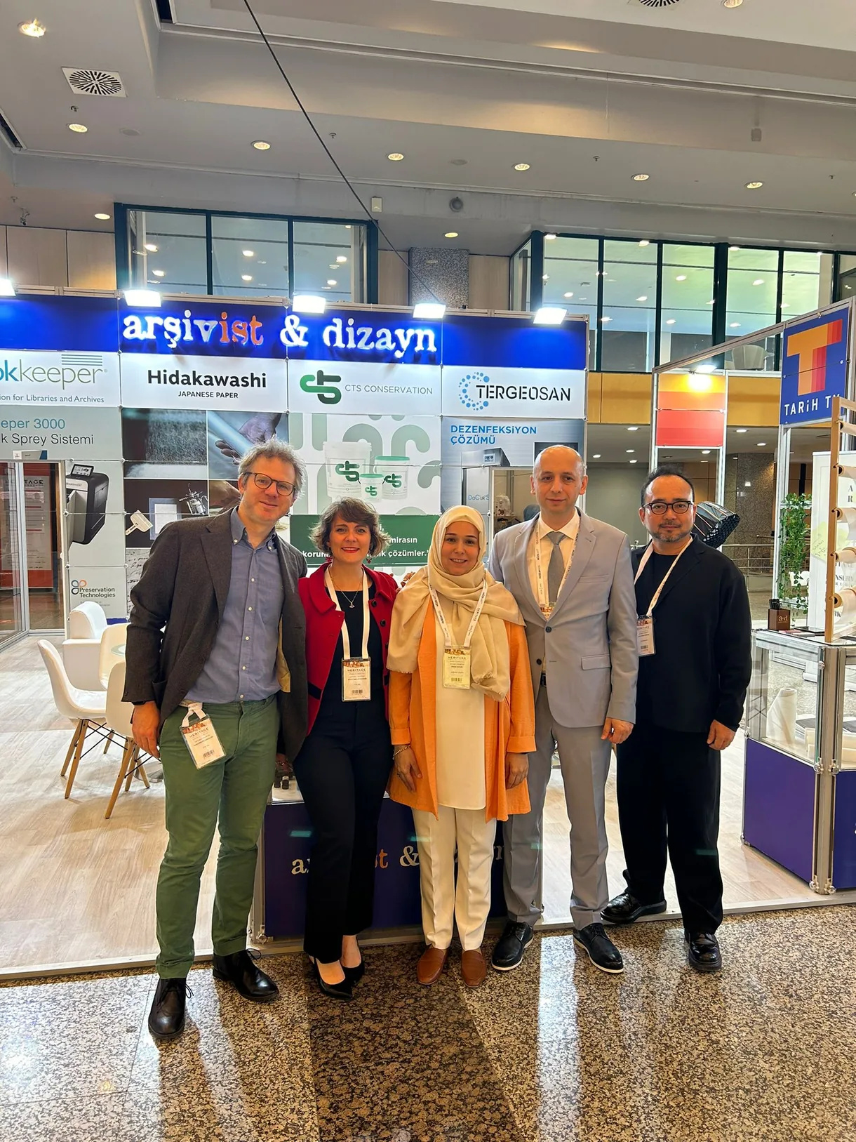 Heritage İstanbul 2024 fuarında Arşivist & Dizayn ekibinin stant önünde grup fotoğrafı